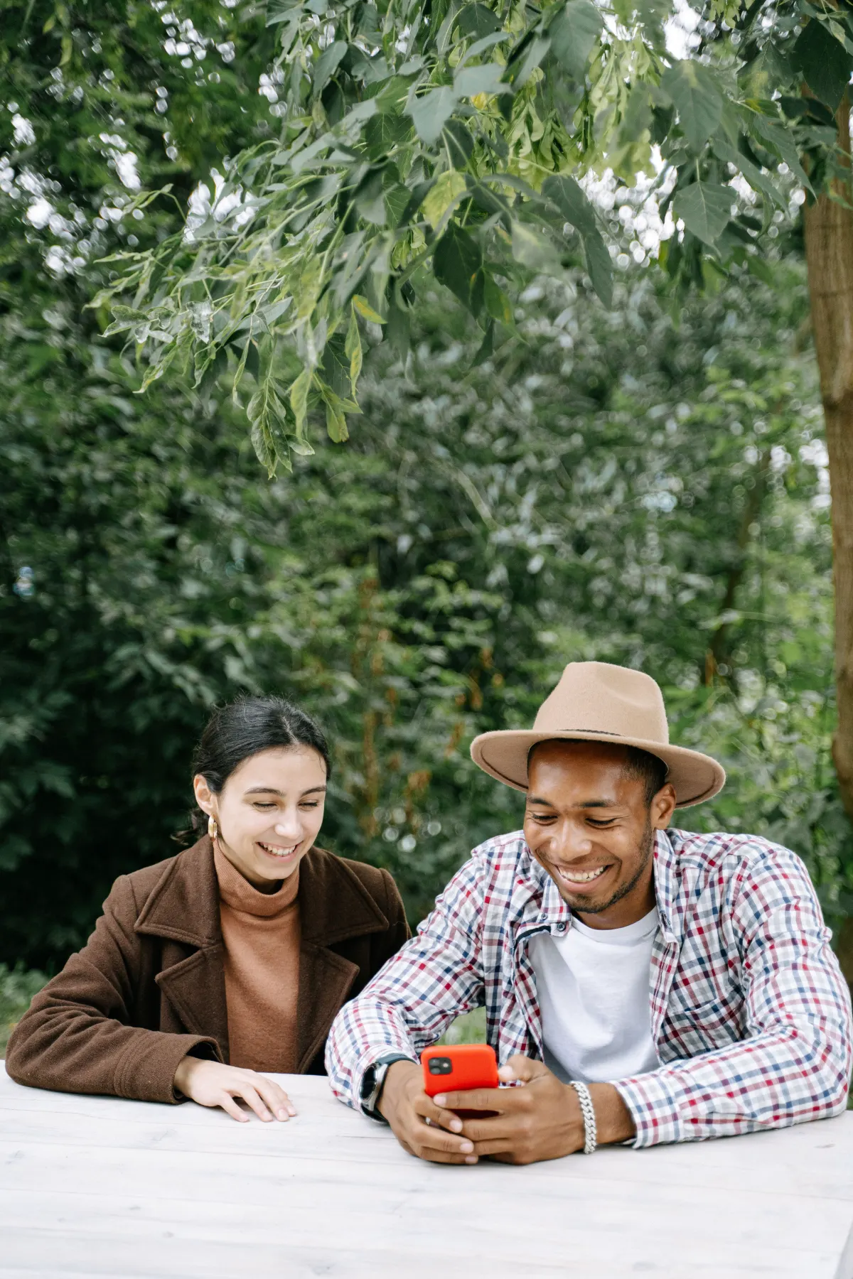 Two smiling people using the Tundr welfare app on a smartphone